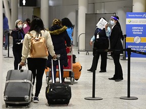 Travellers arrive at Pearson Airport in Toronto on Feb. 22, 2021.