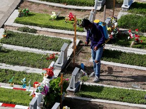 A cemetery worker disinfects graves at the Flores cemetery, amid the COVID-19 pandemic in Buenos Aires, Argentina, on April 21, 2021.