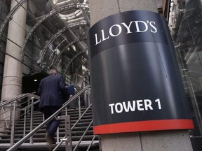 A man walks up the stairs by the main entrance to Lloyd's of London building in the City of London.