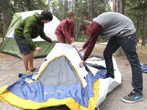 Friends Brandon Line, Connor Lengkeek and Tristan Hughes set up their tent at the Tunnel Mountain campground in Banff National Park on May 17, 2013.
