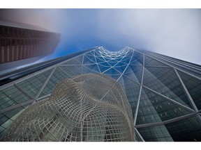 Afternoon sunlight catches the top floors of The Bow tower as the lower section remained in the fog on Tuesday, November 17, 2020.