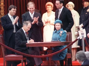 Queen Elizabeth II at Canada's constitutional proclamation in Ottawa on April 17, 1982; here, Prime Minister Pierre Trudeau signs the document.  Postmedia archives photo.