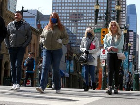 Masked pedestrians are seen walking along Stephen Avenue SW. Friday, April 2, 2021.