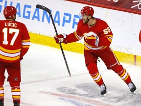 Calgary Flames defenceman Noah Hanifin (right) celebrates after scoring on Edmonton Oilers goalie Mike Smith at the Scotiabank Saddledome in Calgary on Monday, March 15, 2021.