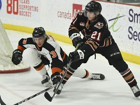 The Calgary Hitmen's Riley Fiddler-Schultz fends off the Medicine Hat Tigers' Rhett Parsons at the Seven Chiefs Sportsplex on Tsuut'ina Nation on Saturday, April 3, 2021.