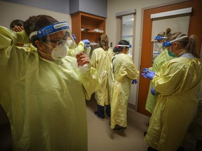 Nurses prepare to treat a COVID-19 patient at Peter Lougheed Hospital on Nov. 14, 2020.
