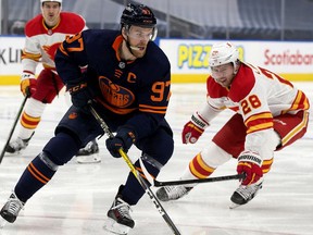 The Edmonton Oilers' Connor McDavid (97) battles the Calgary Flames' Elias Lindholm (28) during third period NHL action at Rogers Place, in Edmonton Thursday April 29, 2021. The Flames won 3-1. Photo by David Bloom