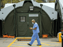 A healthcare worker walks among the tents of a field hospital set up to house patients recovering from COVID-19 at Sunnybrook Hospital in Toronto, April 28, 2021.