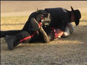 An image from a video taken by Celina Tibo and posted to Facebook shows a Calgary police officer tackling a 12-year-old.