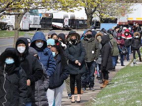 Residents line up for a special "hot spot" vaccination clinic at Downsview Arena in Toronto on Wednesday, April 21, 2021.