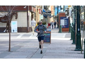 A man is seen jogging along Stephen Avenue in Calgary during a warm afternoon, Wednesday, March 17, 2021.