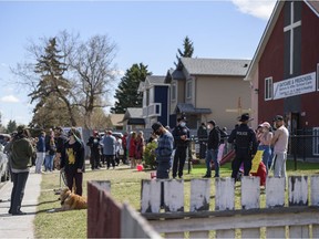 A group of community members have gathered on the lawn neighbouring Street Church, which is holding a gathering despite COVID-19 restrictions, on Saturday, May 1, 2021. The neighbours of the church say they feel unsafe and harassed by the churchgoers and their pastor Arthur Pawlowski.   Azin Ghaffari/Postmedia