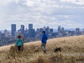 People and their dogs go for an afternoon walk in Nose Hill Park as the clouds and sunshine take turns in Calgary’s sky on Sunday, May 2, 2021.
