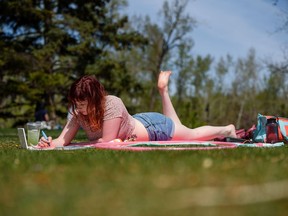 Amandah Necker spends the warm and sunny afternoon painting at Prince's Island Park on Saturday, May 15, 2021. It could be good sunbathing weather this week as temperatures are expected to top 30 C.