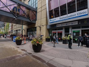 People wait in line to receive their COVID-19 vaccine at the Immunization Clinic in the Telus Convention Centre on Wednesday, May 19, 2021.