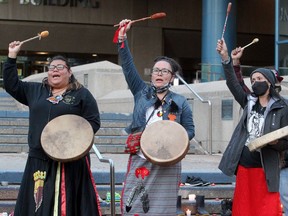 Pearl White Quills (middle) is seen drumming at a Candlelight Vigil for the Children of Tkemlups Residential School. 215 pairs of children's shoes were displayed on the steps of City Hall. Saturday, May 29, 2021.