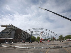 Employees from Warner Shelter Systems Limited work on the Nashville North structure on the the Stampede grounds in Calgary on Thursday, May 27, 2021.