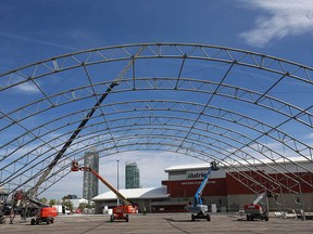 Employees from Warner Shelter Systems Limited works on the Nashville North structure on the the Stampede grounds in Calgary on Thursday, May 27, 2021.