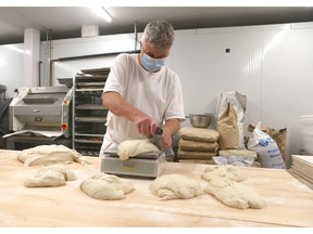 Lutz Kuenz cuts and weighs dough at Cravings in Granary Road on the southwest edge of Calgary on May 27, 2021. Jim Wells/Postmedia