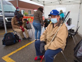 Gordon Ducharme waits for 15 minutes after receiving a COVID-19 vaccination at a pop-up vaccination clinic at the Chinook CTrain parking lot on Thursday, May 20, 2021. Alberta Health Services Safeworks and the Alpha House Encampment team collaborated with the clinic to target vulnerable Calgarians who may have trouble accessing vaccinations.