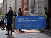 People queue to receive a COVID-19 vaccine at a temporary vaccination centre in central London on May 18, 2021.