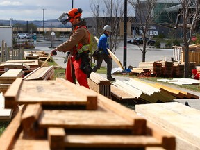 Construction workers organize lumber at a condominium development in Seton on Tuesday, May 11, 2021. Surging lumber prices have created a spike in lumber thefts in Calgary.