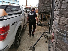 A pickup truck is extricated from a wall on The Pint Public House on 17th Avenue S.W. on Thursday, May 13, 2021. A driver and passenger fled the scene after the collision.