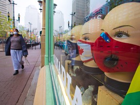 Masked mannequins look out a shop window as Calgarians walk into the downtown COVID-19 immunization clinic on a cool morning, Thursday, May 20, 2021.