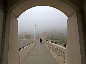 The downtown Calgary skyline is hidden by fog as a commuter crosses the Centre Street bridge on Wednesday, May 26, 2021.