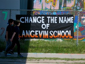Langevin School students in Calgary walk past a sign calling for the school name to be changed on Monday, May 31, 2021.  The school was named after Hector-Louis Langevin who was the “architect” of the residential schools in Canada. Its name has since been changed to Riverside School.
