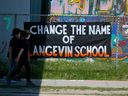 Langevin School students in Calgary walk past a sign calling for the school's name to be changed on Monday, May 31, 2021. The school is named after Hector-Louis Langevin who the 