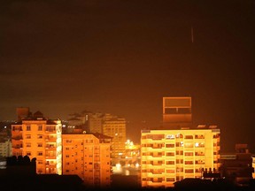 A picture taken on May 15, 2021 shows explosion after an Israeli airstrike struck the Andalus Tower in Gaza city, controlled by the Palestinian Hamas movement. - Israel pummelled the Gaza Strip with air strikes, killing 10 members of an extended family and demolishing a building housing international media outlets, as Palestinian militants fired back barrages of rockets.