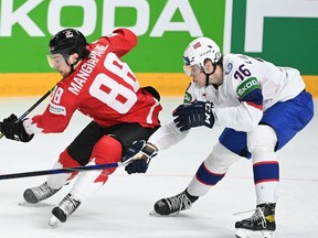Canada's Andrew Mangiapane (L) and Norway's defender Emil Lilleberg vie during the IIHF Men's Ice Hockey World Championships preliminary round group B match Canada vs Norway, at the Arena Riga in Riga, on May 26, 2021. (Photo by Gints IVUSKANS / AFP)