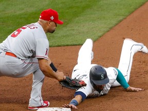 May 1, 2021; Seattle, Washington, USA; Seattle Mariners designated hitter Jose Marmolejos (26) get picked off by Los Angeles Angels first baseman Albert Pujols (5) during the fourth inning at T-Mobile Park. Mandatory Credit: Jennifer Buchanan-USA TODAY Sports ORG XMIT: IMAGN-432050