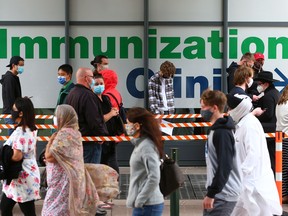 People line up for COVID-19 vaccinations at the Telus Convention Centre in Calgary on May 22, 2021.