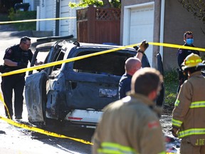 Police investigate a burned-out vehicle believed to be used in a fatal shooting in a nearby alley in the 1800 block of 26th Avenue S.W. in South Calgary on Saturday, May 22, 2021.
