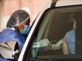 FILE - A person receives the Pfizer/BioNTech vaccine against the coronavirus disease (COVID-19) at a drive-thru vaccination spot for health workers, in Bogota, Colombia April 10, 2021. Quebec plans to offer drive-thru vaccination sites.