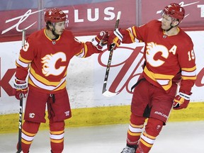 May 19, 2021; Calgary, Alberta, CAN; Calgary Flames forward Matthew Tkachuk (19) celebrates his second period goal with forward Johnny Gaudreau (13) against the Vancouver Canucks at Scotiabank Saddledome. Mandatory Credit: Candice Ward-USA TODAY Sports ORG XMIT: IMAGN-451011