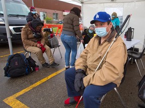 Gordon Ducharme waits for 15 minutes after receiving a COVID-19 shot at a pop-up vaccination clinic at the Chinook CTrain parking lot on Thursday, May 20, 2021. AHS Safeworks and the Alpha House Encampment team collaborated with the clinic for vulnerable Calgarians.