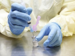 UHN (University Health Network) health-care technicians in Toronto prepare syringes of the Pfizer-BioNTech COVID-19 vaccine for front-line health-care workers on Jan. 7, 2021.