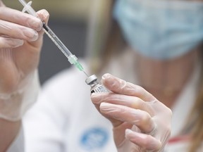 Pharmacist Alison Davison prepares a dose of the Pfizer-BioNTech COVID-19 vaccine at Shoppers Drug Mart on 17 Ave. SW in Calgary on March 5, 2021.