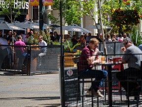 People spend the sunny lunch hour on the patios on Stephen Avenue as restaurants reopen for outdoor dining on Tuesday, June 1, 2021.