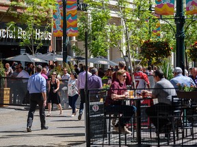 People spend the sunny lunch hour on the patios on Stephen Avenue as restaurants reopen for outdoor dining on Tuesday, June 1, 2021.