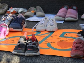 Approximately 200 childrens' shoes, boots and moccasins were placed on the steps of St. Columbkille's Cathedral in Pembroke Monday evening as a memorial to the 215 children whose remains were discovered on the grounds of a residential school in Kamloops, B.C.