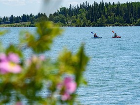 Two kayakers spent the hot summer afternoon paddling in the Glenmore reservoir as the wild roses have bloomed in Calgary on Tuesday, June 22, 2021.