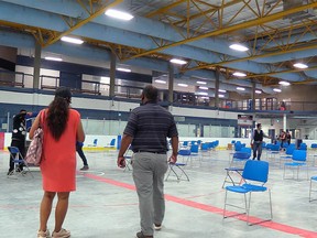 Organizers prepare a pop-up, walk-in COVID-19 vaccine clinic in a hockey rink at Village Square Leisure Centre in northeast Calgary on Wednesday, June 2, 2021. The clinic, scheduled for June 5-6 will be operating for first shots of Pfizer vaccine and according to an image in a recent tweet, no Alberta Health Care is required, only proof of identity.