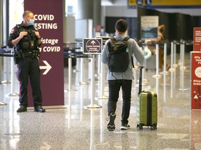 A passenger is guided into COVID testing area the International arrivals area at the Calgary International Airport on Wednesday, June 9, 2021.