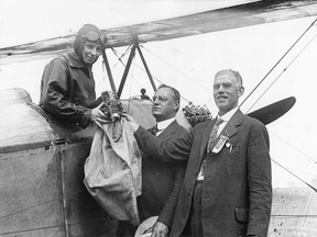 Katherine Stinson hands over a mail bag to postmaster George Armstrong and W.S. Starke, manager of the Edmonton Exhibition. Postmedia archives, photo courtesy McDermid Studios.