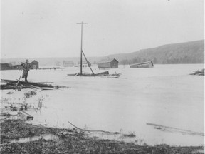 A view west from the old Langevin Bridge, during the June 1897 flood in Calgary; a man stands on the shore to survey the damage. Calgary Herald file photo.