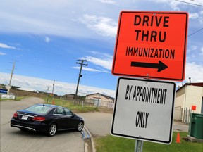 Cars head into a drive-thru COVID-19 vaccination centre that opened in the previous drive-thru testing location on 32nd Avenue N.E. on Monday, June 7, 2021.